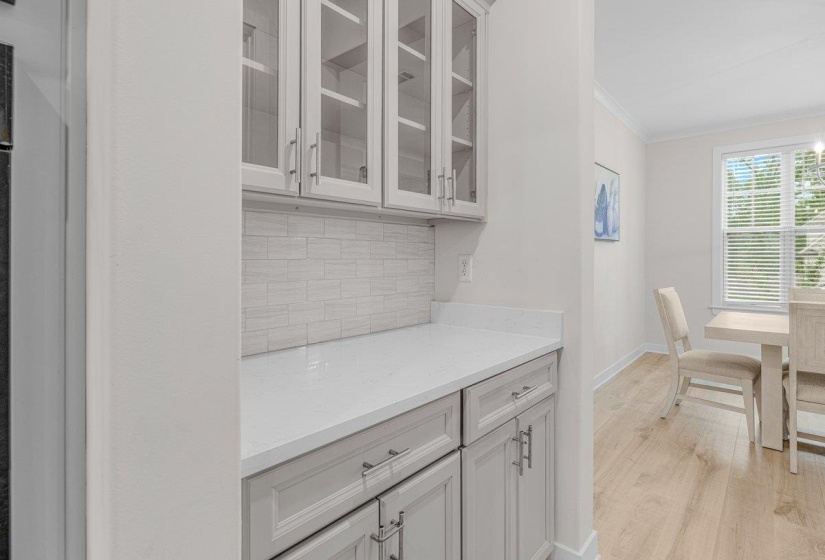 Built-in cabinetry with glass-front uppers, solid lower cabinets, and a light countertop