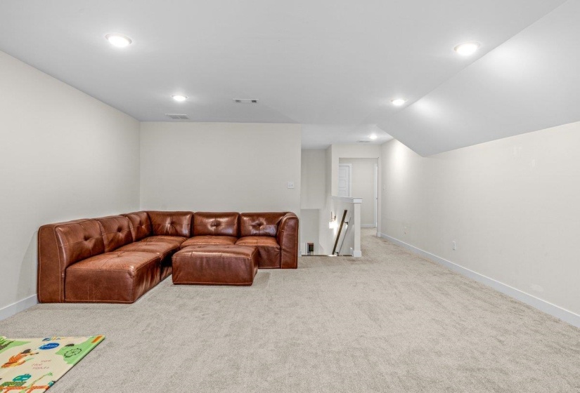 Spacious room featuring neutral carpeting and recessed lighting