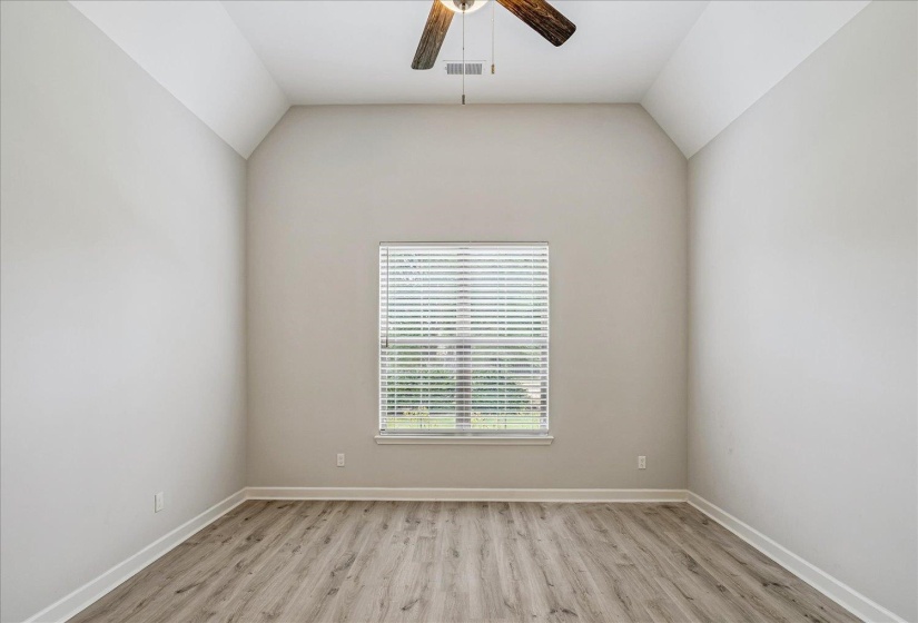 Room with vaulted ceilings and wood-finish flooring