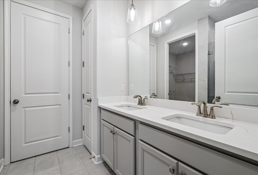 Double vanity featuring light gray cabinetry, brushed nickel hardware, and white countertops with integrated sinks