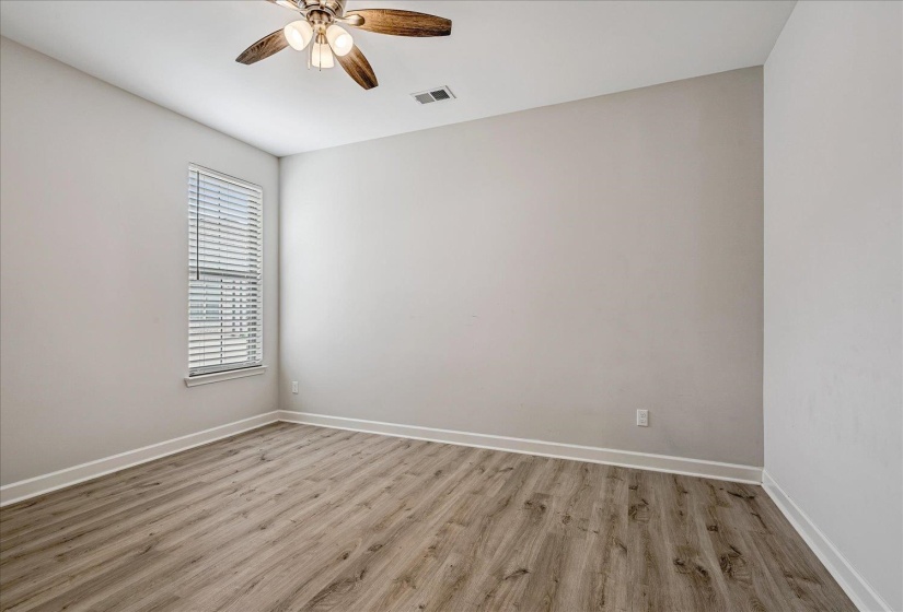 Interior room featuring light wood-finish flooring, neutral wall paint, and white baseboards