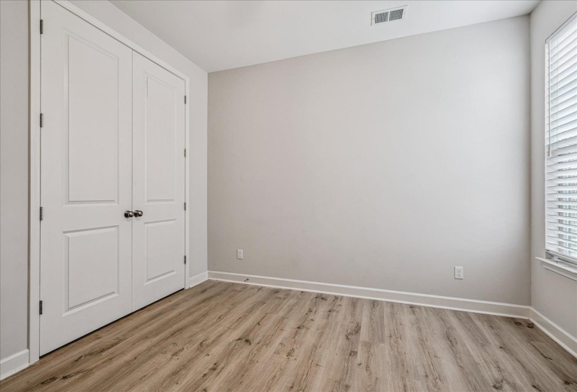Room featuring wood-finish flooring, light gray walls, and white baseboards
