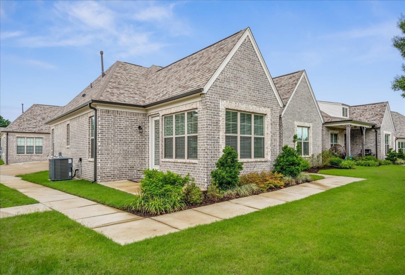 Gray brick exterior featuring multiple gables and a shingle roof