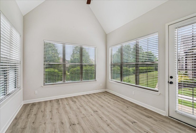 Room featuring a vaulted ceiling and wood-finish flooring