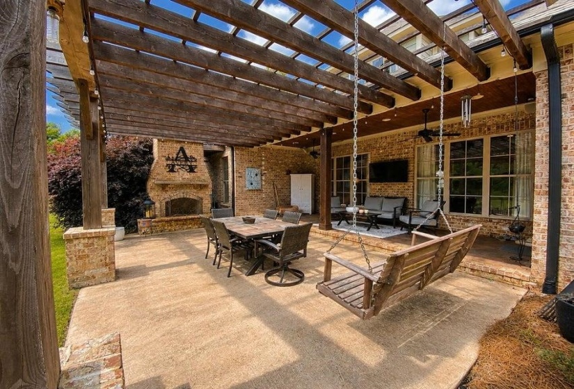 Expansive outdoor living area featuring a wood pergola and concrete patio
