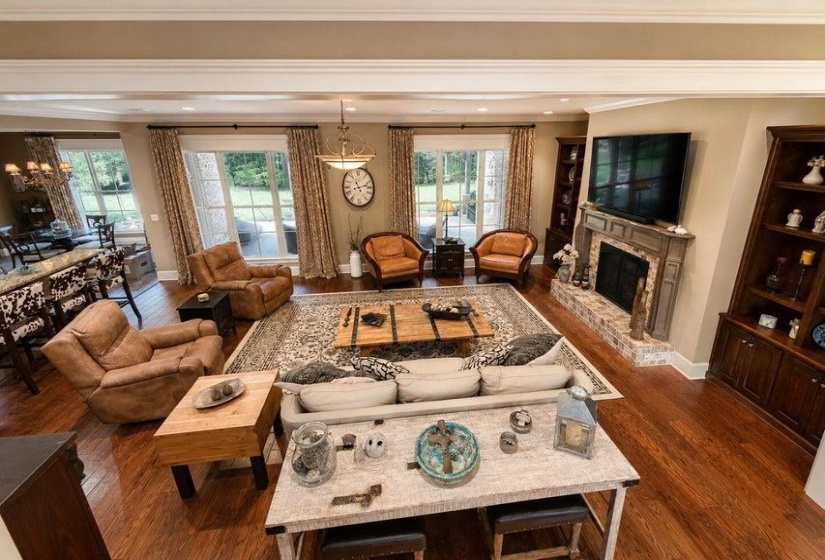 Spacious living area featuring rich wood-finish flooring, with a  beautiful fireplace
