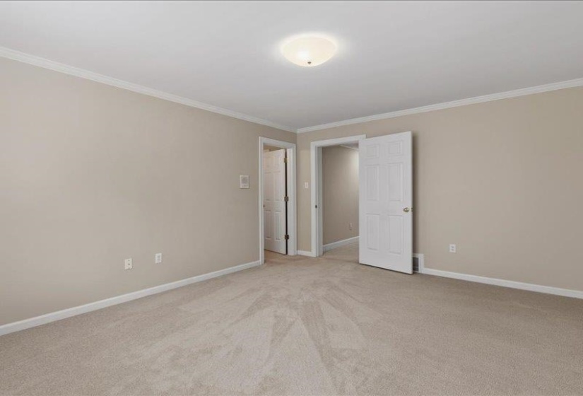 Carpeted room with neutral wall tones and white trim