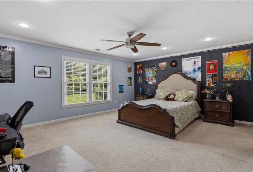 Spacious room featuring light-colored carpet flooring and a ceiling fan with integrated lighting
