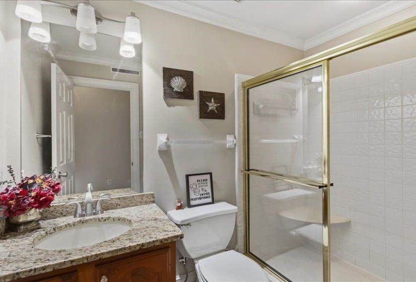 Bathroom featuring a vanity with a granite-finish countertop, undermount sink, and polished chrome faucet