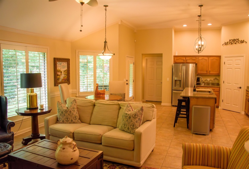 Open concept living area featuring vaulted ceilings, wood-finish flooring, and recessed lighting