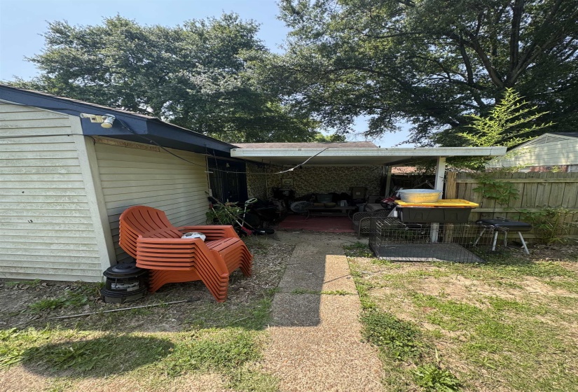 Covered patio area with a concrete slab and a gravel path
