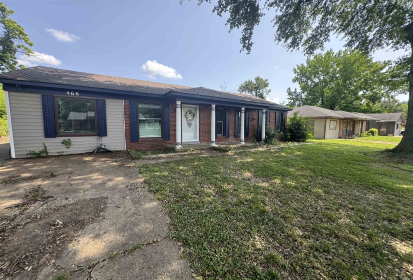 Ranch-style exterior featuring brick and horizontal siding, a covered front entry with columns, and dark blue window shutters