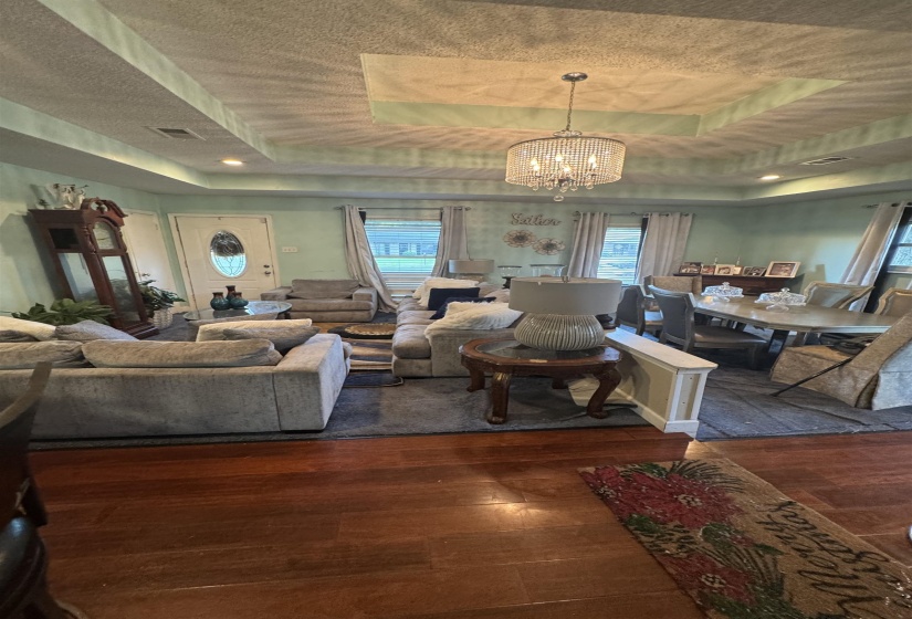 Tray ceiling with recessed lighting and a decorative chandelier