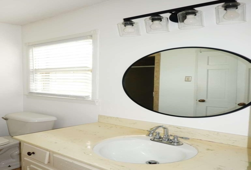 Bathroom vanity featuring an oval undermount sink, dual-handle chrome faucet, and light-toned countertop