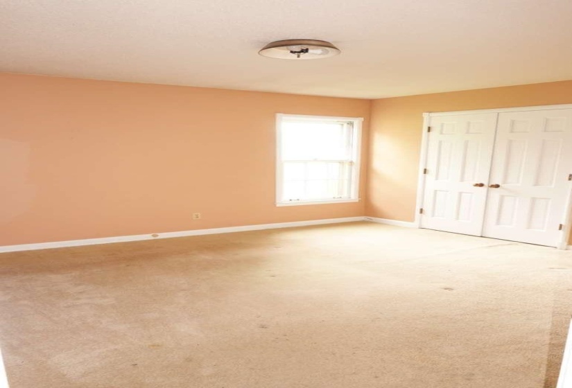 Room featuring neutral-toned carpeting, light-colored walls, and a white trim baseboard