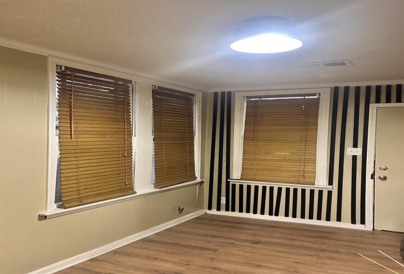 Den with light wood-style flooring and baseboards