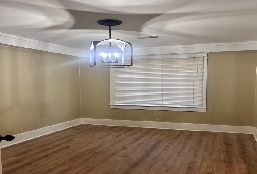 Bedroom with wood-type flooring, wooden walls, and a chandelier