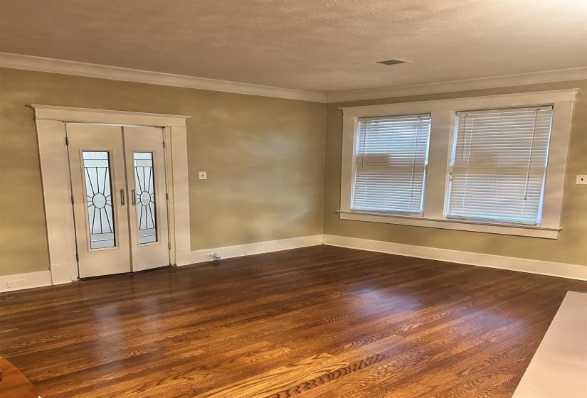Entrance foyer with french doors, dark wood-type flooring, and ornamental molding