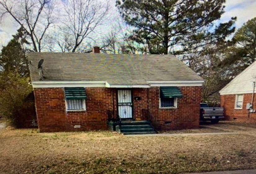 View of front of property with brick siding and crawl space