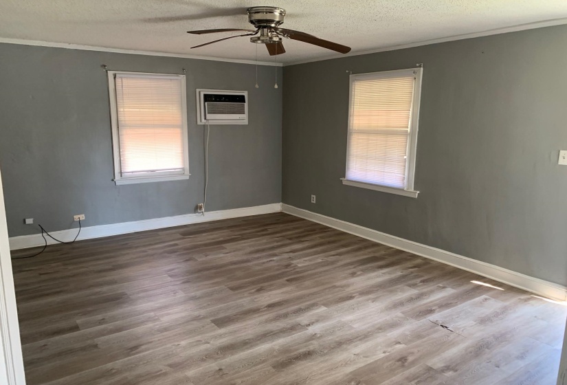 Unfurnished room featuring crown molding, wood-type flooring, a textured ceiling, and a wall mounted AC
