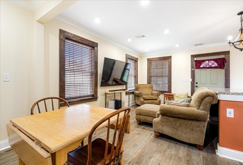 Dining area with light wood finished floors, ornamental molding, and recessed lighting