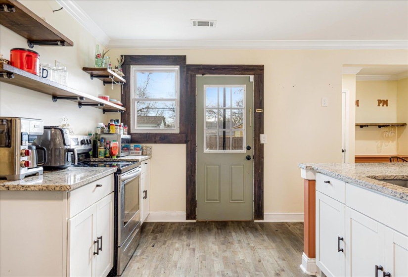 Kitchen featuring crown molding, light stone countertops, electric stove, white cabinets, and light wood-type flooring