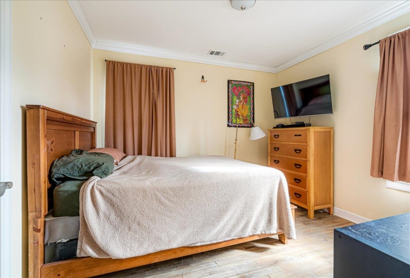 Bedroom with hardwood / wood-style flooring and crown molding