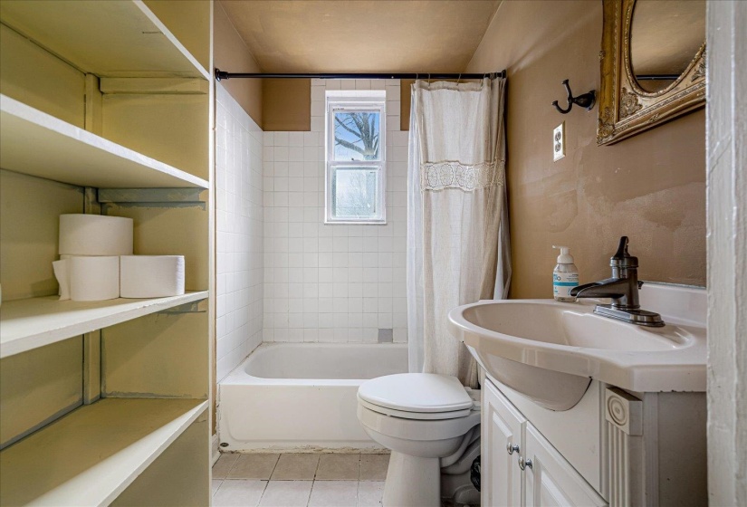 Full bath with vanity, light tile patterned floors, and shower / tub combo