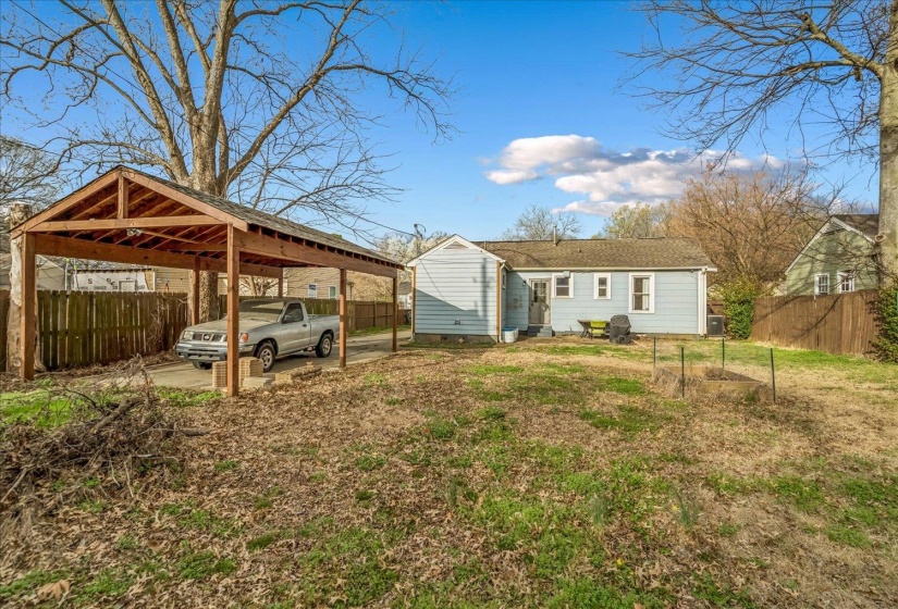 Back of house with a detached carport