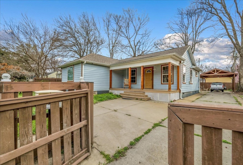 View of front of home featuring covered porch, a shingled roof, and concrete driveway
