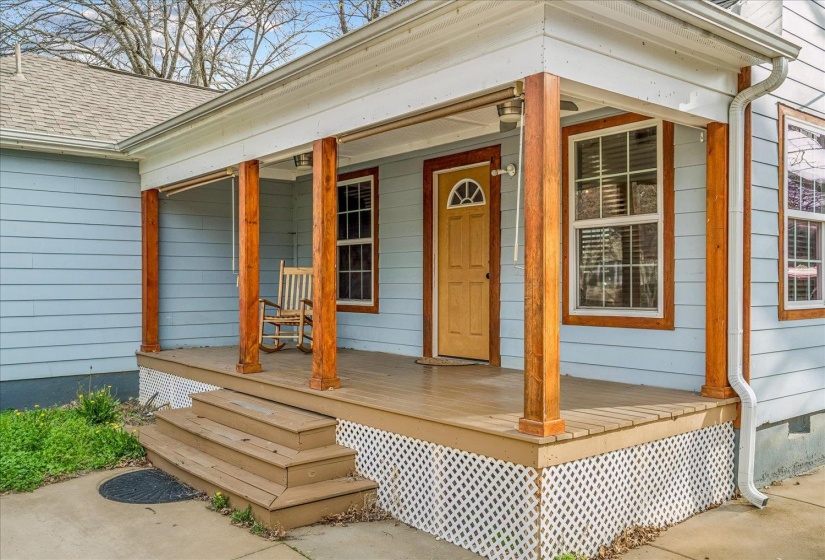 Doorway to property with covered porch and a shingled roof