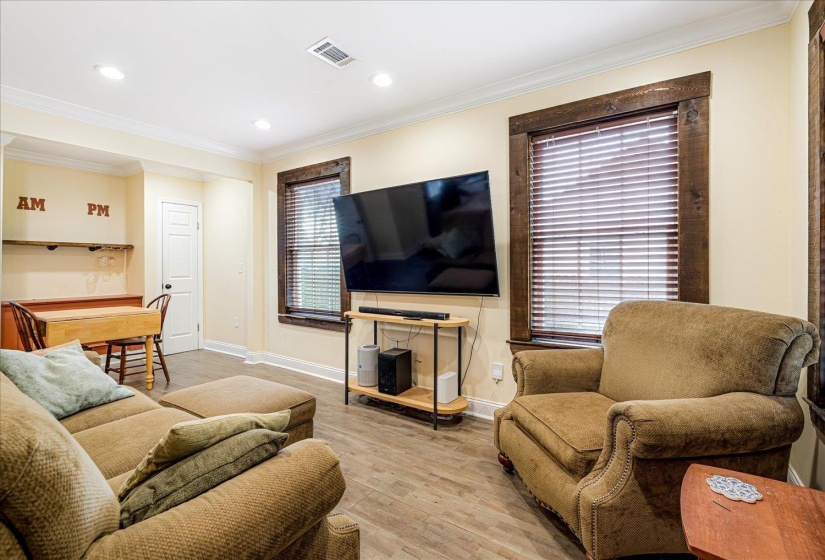Living room featuring crown molding, light wood-style flooring, and recessed lighting