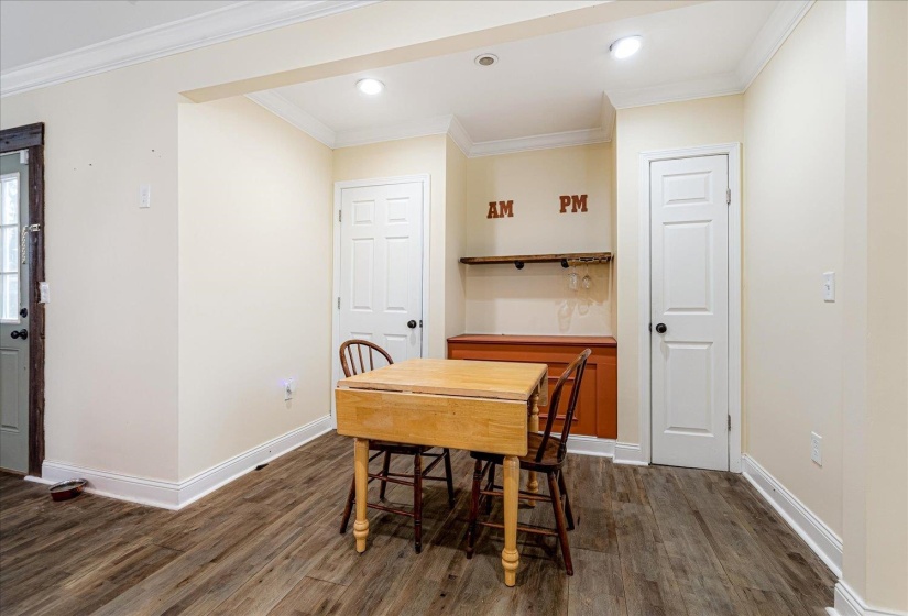 Dining area featuring crown molding, dark wood-type flooring, and recessed lighting