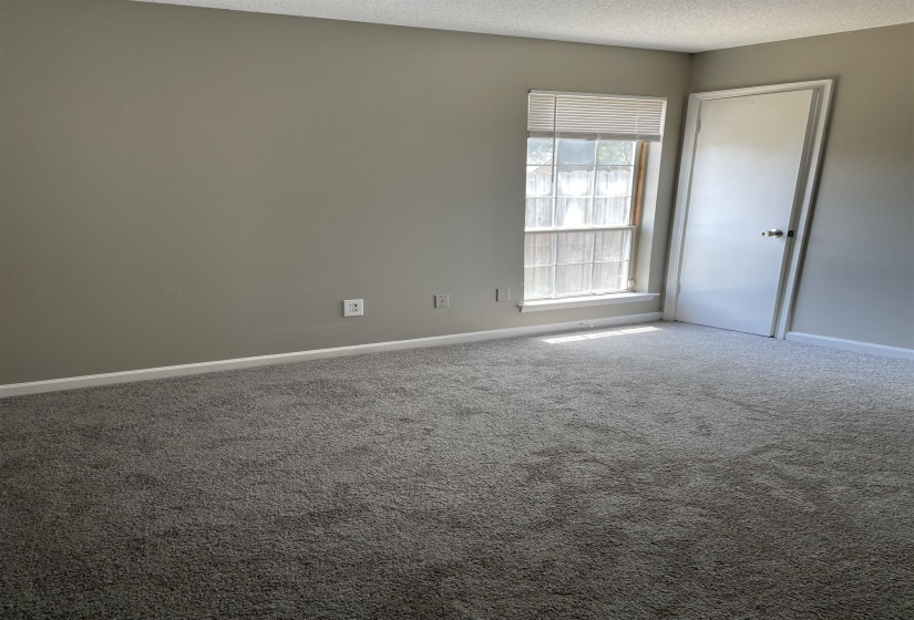 Empty room featuring carpet flooring and a textured ceiling