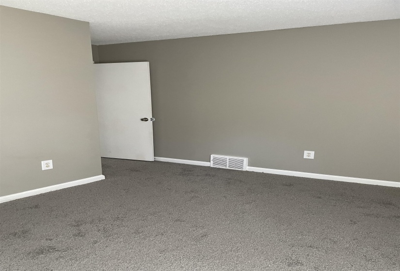 Empty room featuring a textured ceiling and carpet