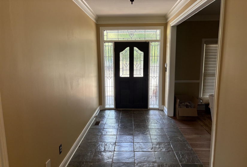 Entryway featuring a dark paneled door with decorative glass, flanked by vertical sidelights and topped with a transom window