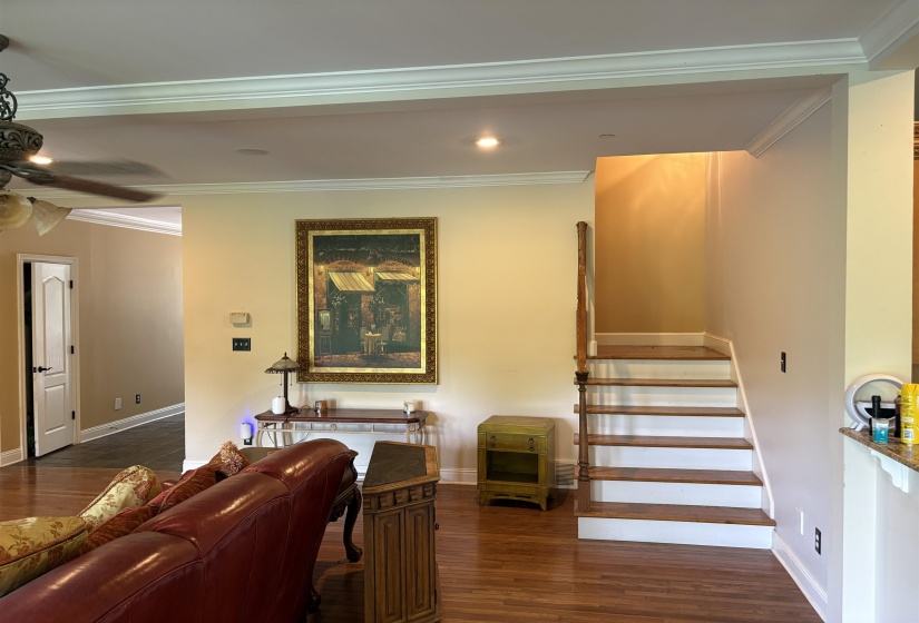 Hardwood flooring extends throughout this interior space, featuring a staircase with painted risers and wood treads
