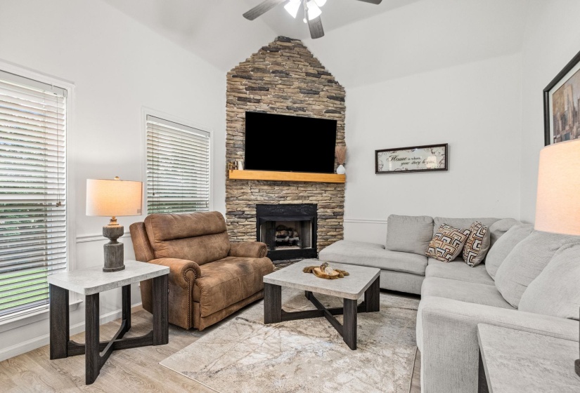 Corner fireplace featuring a stacked stone surround and wood mantel
