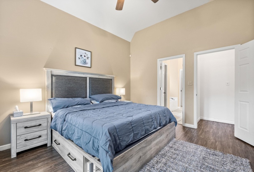 Vaulted ceilings enhance this room, featuring wood-finish flooring and neutral wall tones