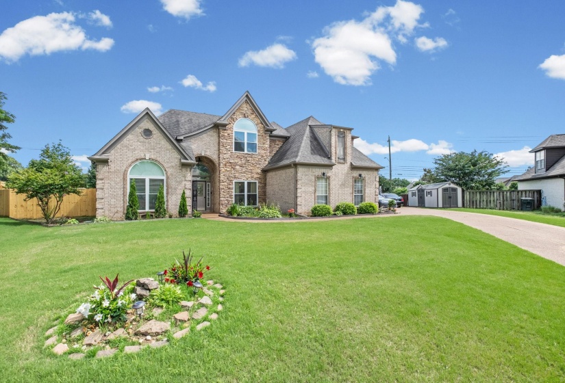 Stately two-story residence featuring a brick and stone facade with multiple gables