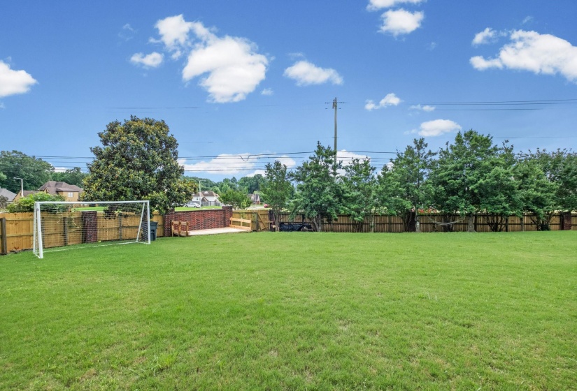 Expansive green lawn with a wood fence perimeter