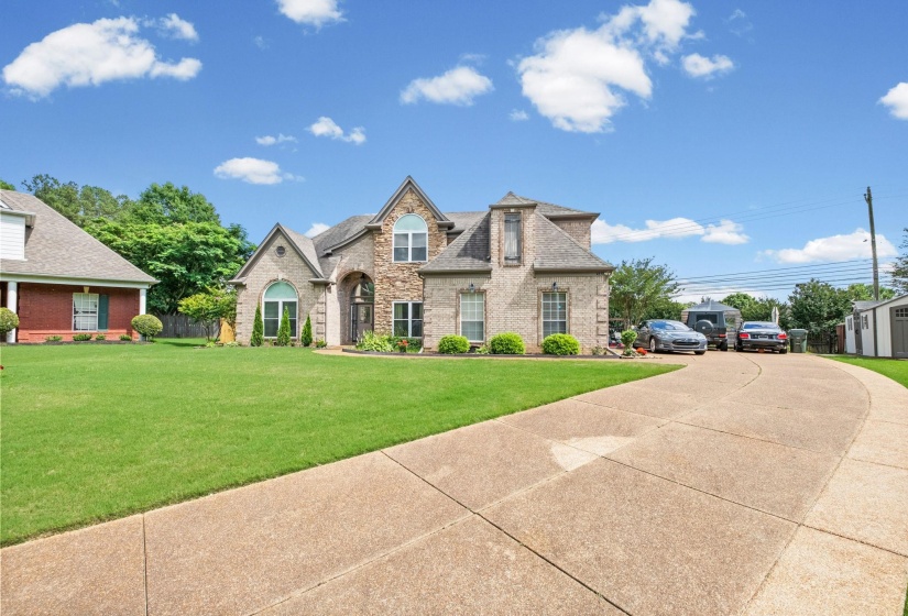 Stone and brick facade residence with an arched entry and dormer windows