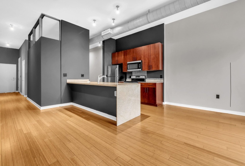 Kitchen area featuring wood-finish cabinetry, stainless steel appliances, and a tiled backsplash