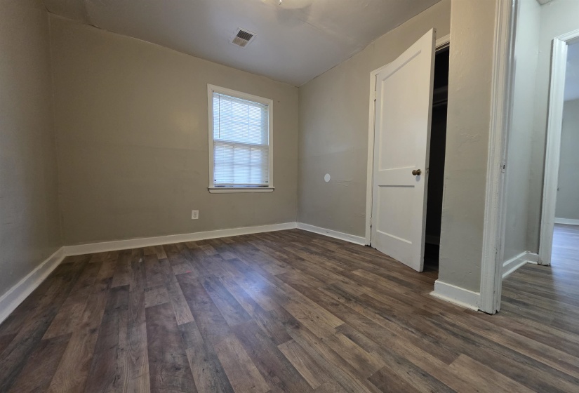 Room featuring wood-finish flooring, neutral wall paint, and white trim