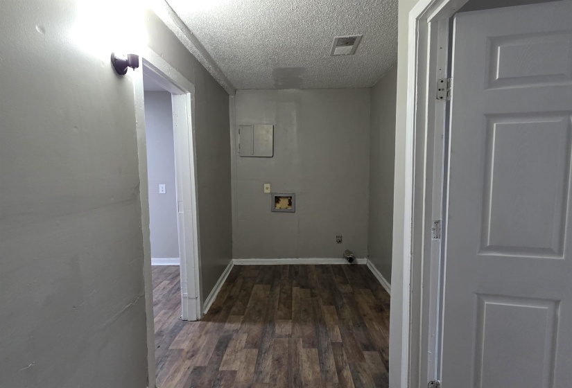 Utility area featuring wood-finish flooring, light gray wall paint, and white trim