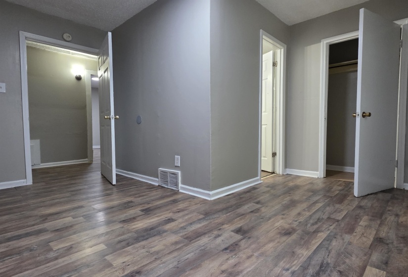 Interior space featuring wood-finish flooring, light gray walls, and white trim