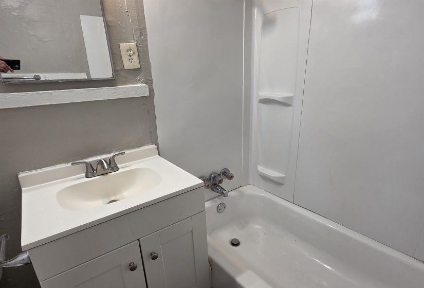 Bathroom vanity with integrated sink, brushed nickel faucet, and white two-door cabinetry