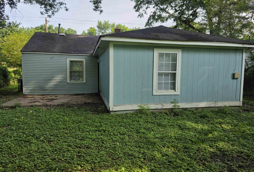 Rear exterior featuring light blue siding and a pitched roof