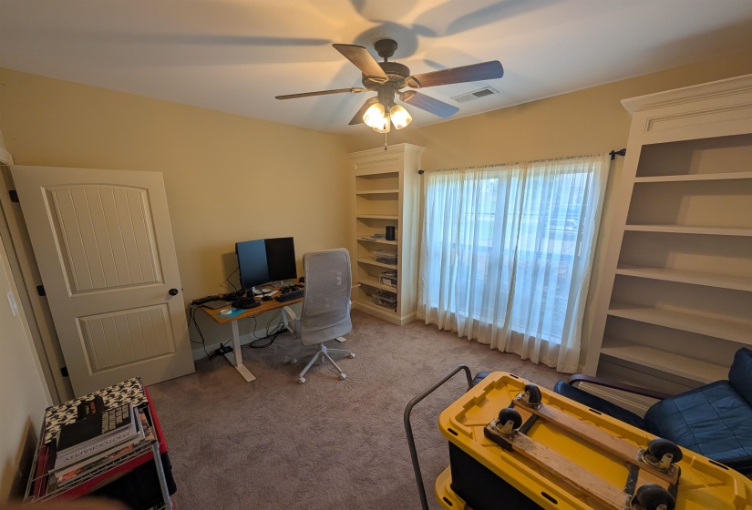 Room featuring recessed lighting, a ceiling fan with integrated lighting, built-in shelving, carpet flooring, and a window with sheer curtains