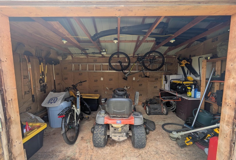Utility shed featuring exposed wood framing and a metal roof